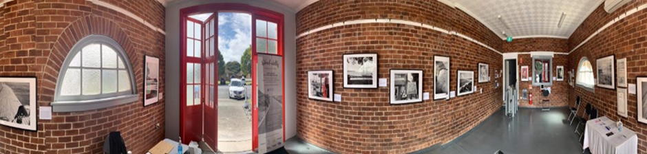 Art works hanging in an old brick gallery which used to be a fire station in Ballina, NSW. There is an accessible lift to the adjacent rooms